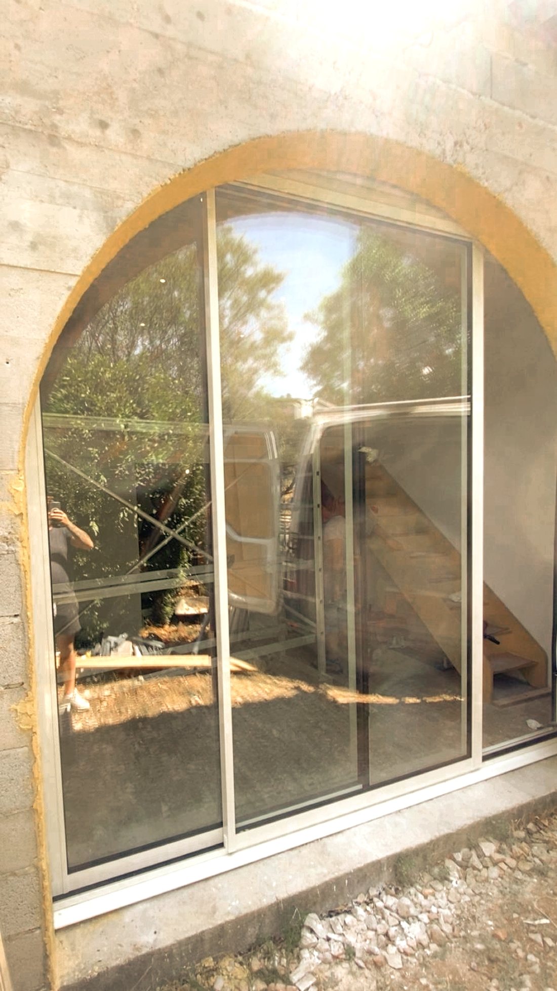 Baie vitrée aluminium blanc posée dans une arche en pierre