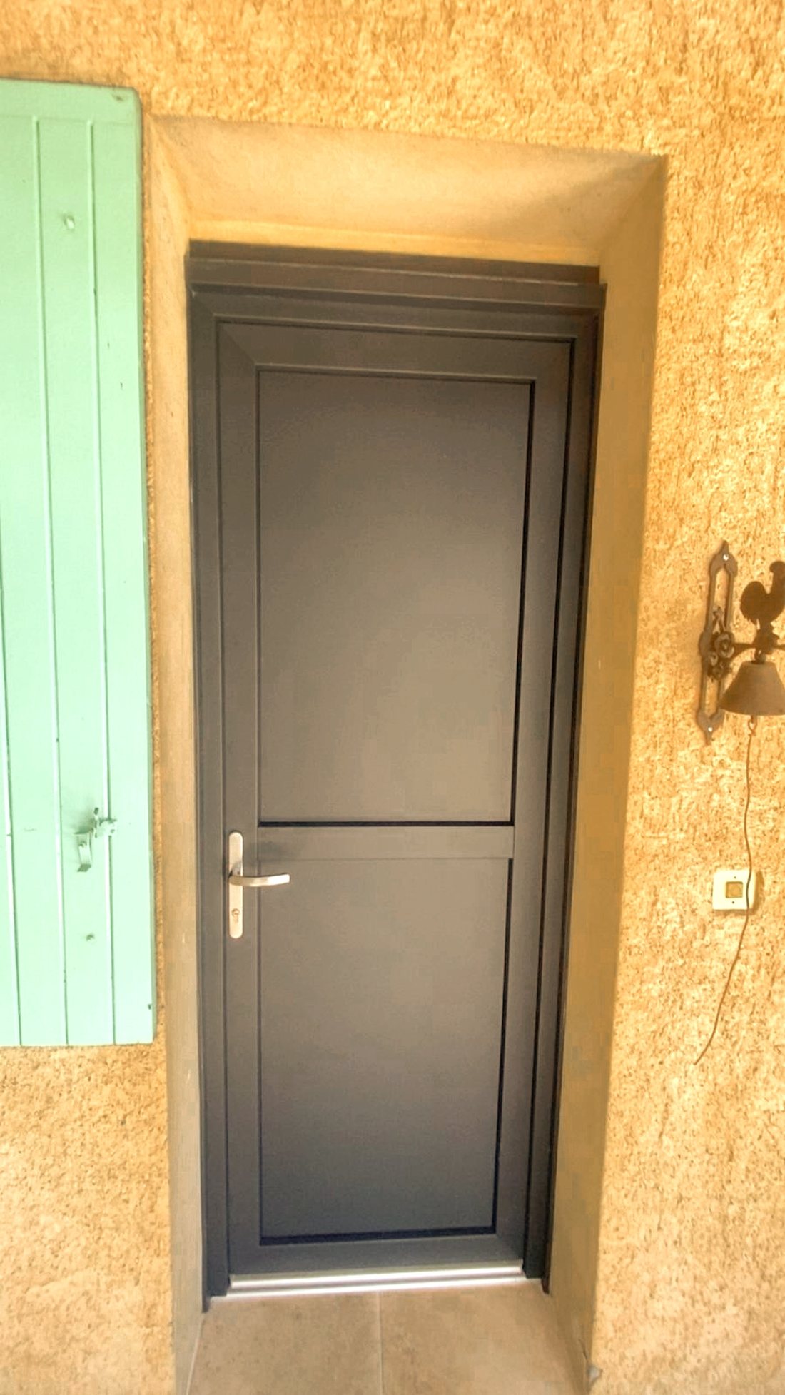 Porte d'entrée aluminium anthracite posée sur façade