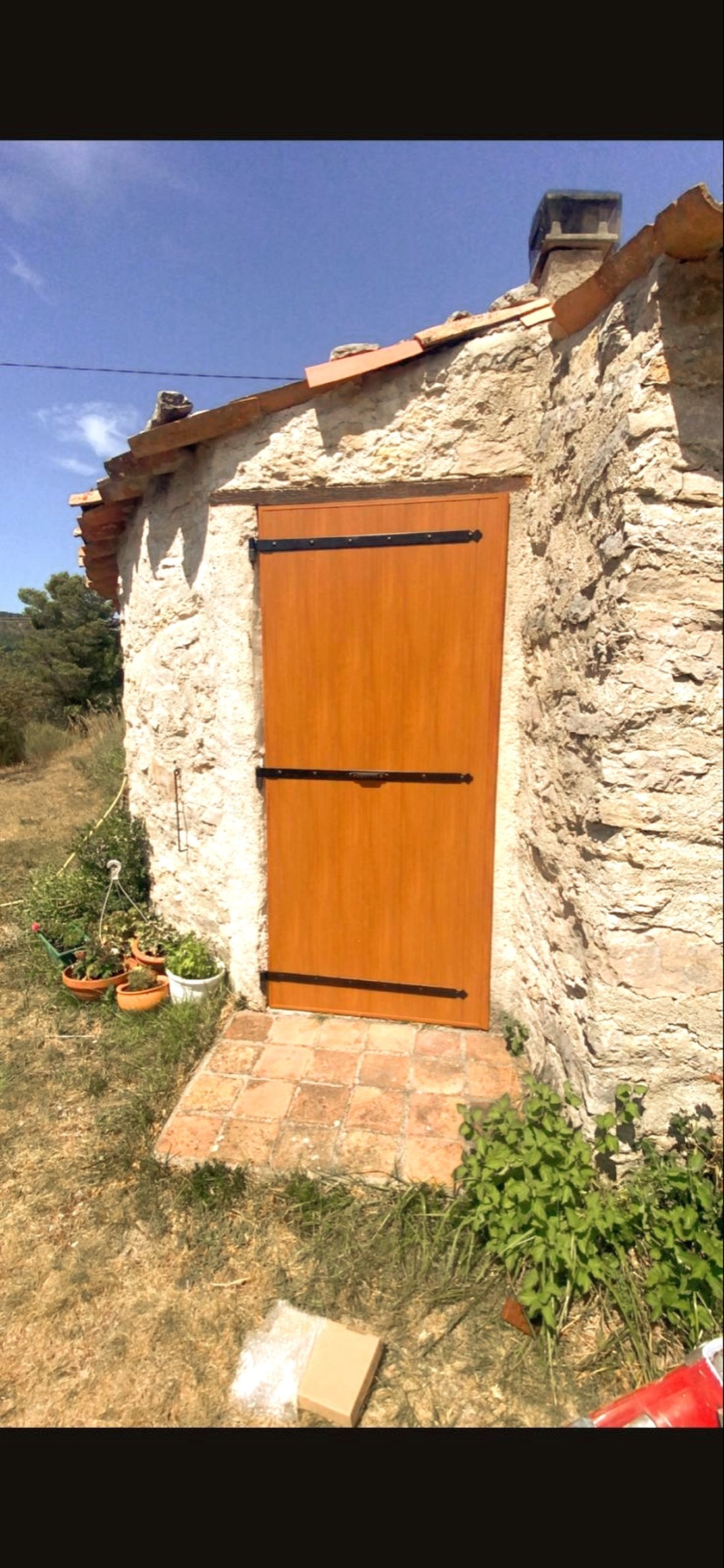 Porte d'entrée blanche avec vitrage courbe posée sous un store banne